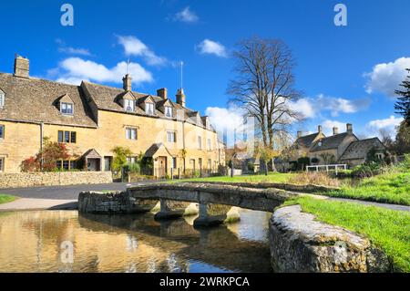 Scena delle Cotswolds con cottage tradizionali e ponte in pietra sul fiume Eye nel pittoresco villaggio di Cotswold Lower Slaughter, Gloucestershire, Inghilterra Regno Unito Foto Stock