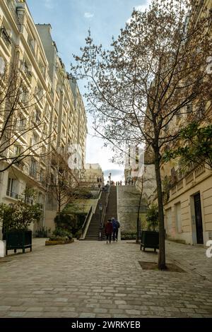 Parigi, Francia - 17 febbraio 2024 : Vista panoramica dei turisti che camminano su e giù per le pittoresche scale nell'area di Montmartre a Parigi Francia Foto Stock