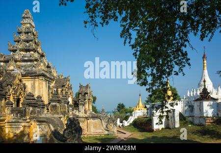 Architettura storica birmana. Pareti gialle ammuffite del monastero di Maha Aungmye Bonzan e pagode bianche e dorate a Inwa (Ava), Myanmar Foto Stock