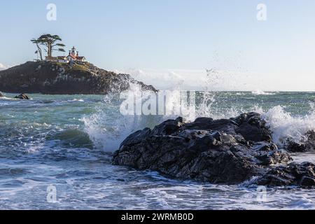 Splendida vista sul faro di Battery Point con onde che spruzzano in primo piano a Crescent City, California. Foto Stock