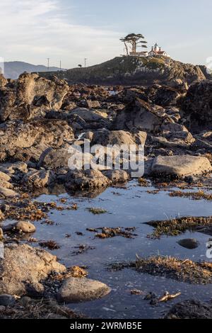 Splendida vista del faro di Battery Point, visto attraverso le rocce e le pozzanghere con riflessi a Crescent City, California. Foto Stock