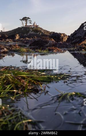 Splendida vista del faro di Battery Point, visto attraverso le rocce e le pozzanghere con riflessi a Crescent City, California. Foto Stock