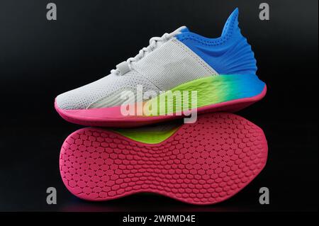 Scarpe sportive colorate e alla moda con suola arcobaleno isolata su sfondo nero Foto Stock