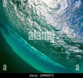 La parte inferiore di un'onda potente catturata con dettagli squisiti, evidenziando le texture e i colori della natura dinamica dell'oceano Foto Stock