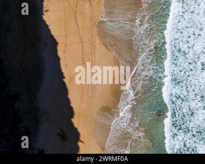 Splendida immagine aerea di un drone che cattura il momento tranquillo in cui le dolci onde accarezzano le coste sabbiose di Fuerteventura, mostrando la delicatezza della natura Foto Stock