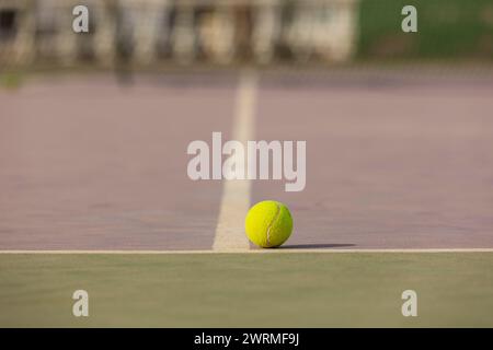 Vista ravvicinata di una palla da tennis sul campo vicino alla linea bianca, che simboleggia una partita in corso o in pausa. Foto Stock