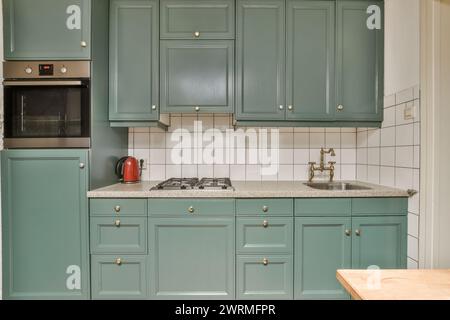 una cucina con armadi blu, lavandino e fornello Foto Stock