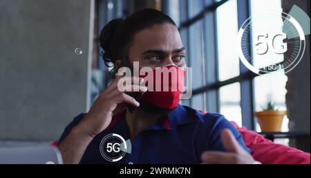 Immagine di interfaccia digitale su uomo birazziale che indossa la maschera in ristorante Foto Stock