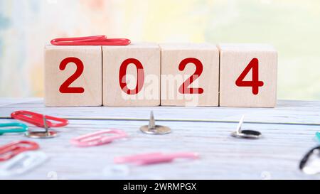 2024 assemblato da cubetti di legno su sfondo colorato Foto Stock