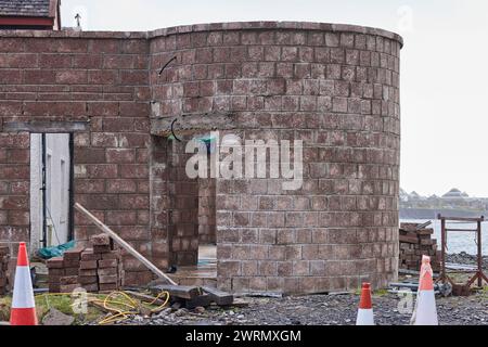 Abbandonati per la giornata, i costruttori lasciano i loro utensili sul posto vicino alla riva di Easdale Sound Foto Stock