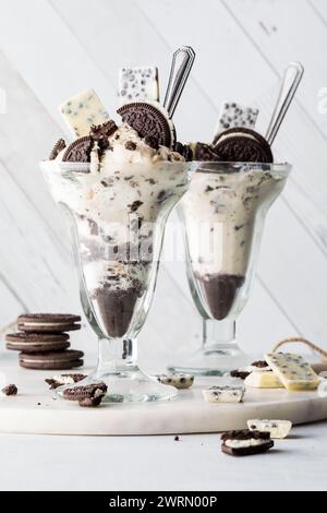 Due biscotti al cioccolato con gelato, pronti per essere mangiati. Foto Stock