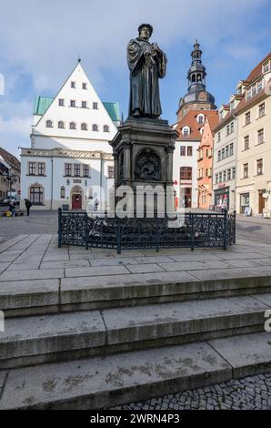 Eisleben, Germania. 7 marzo 2024. Un monumento a Martin Lutero sulla piazza del mercato di Eisleben commemora il riformatore e figlio della città, con St La Chiesa di Andrew sullo sfondo. Eisleben è la seconda città più grande del distretto di Mansfeld-Südharz. Con le case di nascita e morte del riformatore Martin Lutero, Eisleben ha due siti patrimonio mondiale dell'UNESCO. Crediti: Hendrik Schmidt/dpa/Alamy Live News Foto Stock