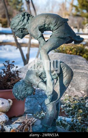 Una toccante e unica scultura commemorativa in bronzo di bambini che giocano a leapfrog che segna una tomba per bambini nel cimitero di Mount Pleasant a Toronto, Ontario Foto Stock