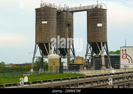 Due grandi silos in piedi accanto a una strada, torreggianti sul paesaggio circostante con la loro presenza industriale. Foto Stock