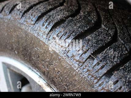 Uno pneumatico di un'auto completamente coperto da uno strato di fango liquido per la vista ravvicinata Foto Stock