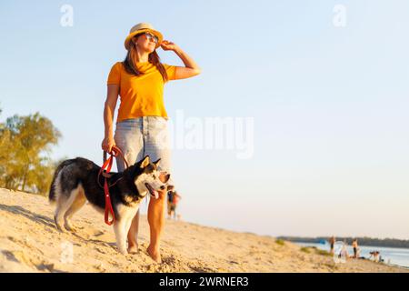 Cane donna che cammina su Sunny Beach Foto Stock