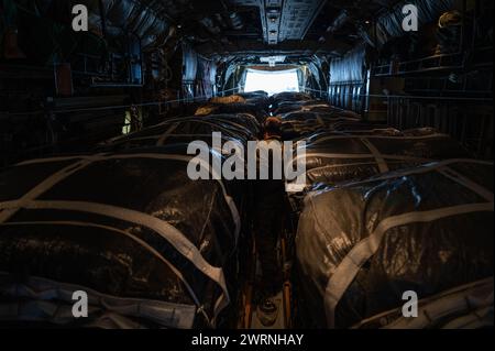 Zarqa, Giordania. 11 marzo 2024. Un comandante della US Air Force controlla i paracadute su pallet di aiuti umanitari nella stiva di carico di un aereo C-130J Super Hercules della US Air Force presso la King Abdullah II Air base, 11 marzo 2024 a Zarqa, Governatorato di Zarqa, Giordania. Gli aiuti alimentari saranno lanciati in aria ai rifugiati palestinesi intrappolati dalla guerra israeliana contro Hamas. Credito: A1C Caleb Parker/US Airforce Photo/Alamy Live News Foto Stock