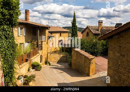 Rue et maisons en pierres dorées typique de cette région du Beaujolais dans le médiéval d’Oingt Foto Stock