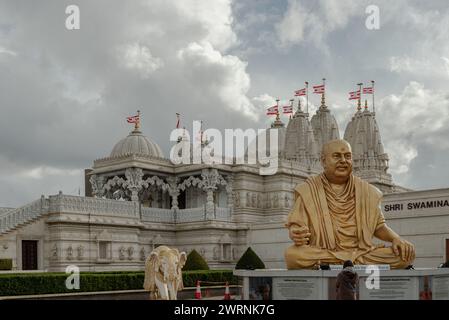 Londra, Regno Unito - 23 febbraio 2024 - Vista esterna del tempio Neasden (BAPS Shri Swaminarayan Mandir) e la statua color oro raffigura il tardo spirituale Foto Stock