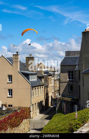 Parapentiste au-dessus de la haute ville de Granville Foto Stock