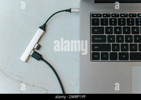 Primo piano dell'hub usb di tipo c con più porte diverse collegate al computer laptop Foto Stock