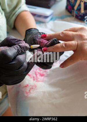 Rimozione della vernice vecchia con un trapano per la vernice permanente per unghie Foto Stock