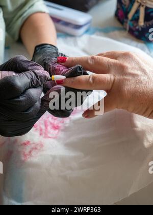 Rimozione della vernice vecchia con un trapano per la vernice permanente per unghie Foto Stock