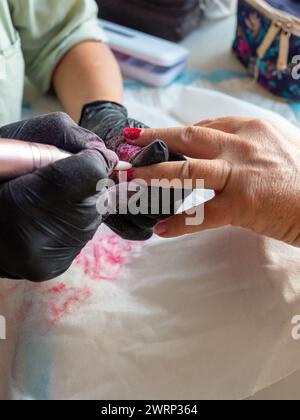 Rimozione della vernice vecchia con un trapano per la vernice permanente per unghie Foto Stock