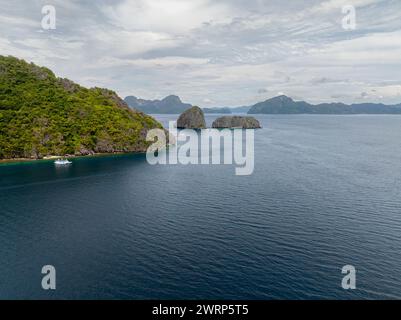 Barca sul mare blu dell'isola di Miniloc. Twin Rocks. El Nido, Palawan. Filippine. Foto Stock