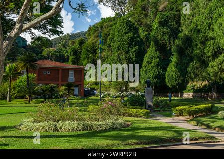 Vista parziale dei verdi giardini di vegetazione di fronte al Palazzo Imperiale di Petropolis nel quartiere Centro durante il pomeriggio estivo cielo azzurro nuvoloso e soleggiato. Foto Stock