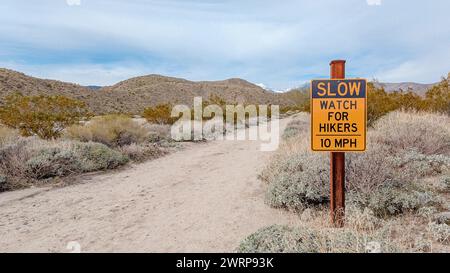 Un cartello lungo un sentiero escursionistico che recita Slow Watch per gli escursionisti nel deserto Foto Stock