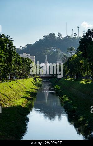 Vista del canale d'acqua del fiume Piabanha che scorre tra Koeler avenue nel quartiere Centro sotto il cielo nuvoloso soleggiato del pomeriggio estivo. Foto Stock