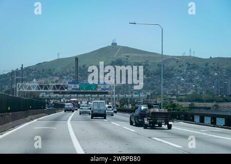 Traffico intenso sul ponte Rio Niteroi vicino alla piazza del pedaggio mentre ti dirigi verso la città di Niteroi sotto il cielo azzurro e soleggiato del pomeriggio estivo. Foto Stock