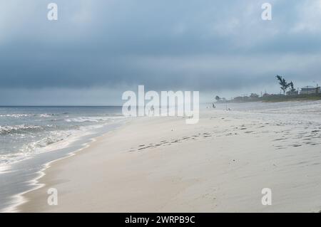 Vista ad ovest della tranquilla e tranquilla spiaggia di Praia Seca, spiaggia di sabbia bianca, acque blu dell'Oceano Atlantico sotto il cielo azzurro nuvoloso del pomeriggio estivo. Foto Stock