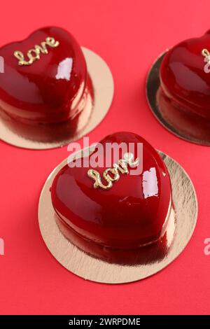 St San Valentino. Deliziose torte a forma di cuore su sfondo rosso, primo piano Foto Stock