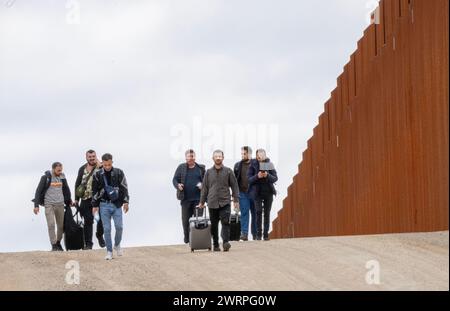 Campo, Stati Uniti. 13 marzo 2024. I migranti camminano lungo il lato degli Stati Uniti del muro di confine con il Messico per arrendersi alla pattuglia di confine degli Stati Uniti vicino a campo, California, il 13 marzo 2024. Un disegno di legge sull'immigrazione bipartisan del Senato per affrontare la questione dell'immigrazione migrante è bloccato nella camera a causa della politica dell'anno elettorale. Foto di Pat Benic/UPI credito: UPI/Alamy Live News Foto Stock