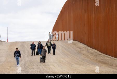 Campo, Stati Uniti. 13 marzo 2024. I migranti camminano lungo il lato degli Stati Uniti del muro di confine con il Messico per arrendersi alla pattuglia di confine degli Stati Uniti vicino a campo, California, il 13 marzo 2024. Un disegno di legge sull'immigrazione bipartisan del Senato per affrontare la questione dell'immigrazione migrante è bloccato nella camera a causa della politica dell'anno elettorale. Foto di Pat Benic/UPI credito: UPI/Alamy Live News Foto Stock