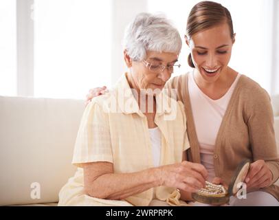 Donna anziana, madre e figlia con il dono per il legame, l'apprezzamento e l'amore rilassarsi sul divano di casa, nel soggiorno e nell'appartamento. Donne Foto Stock