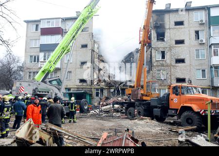 Non esclusiva: SUMY, UCRAINA - 13 MARZO 2023 - i soccorritori utilizzano attrezzature ad alta quota e attrezzi speciali per cercare persone sotto le macerie di un f Foto Stock