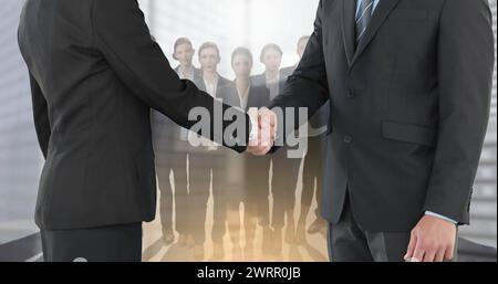 Immagine di un uomo d'affari e di una donna d'affari che stringono la mano su un gruppo di uomini d'affari Foto Stock