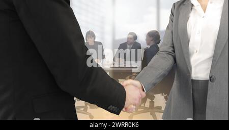 Immagine di un uomo d'affari e di una donna d'affari che stringono la mano su un gruppo di uomini d'affari in carica Foto Stock