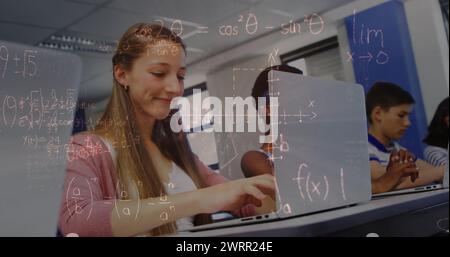 Immagine di equazioni matematiche su scolari con laptop Foto Stock