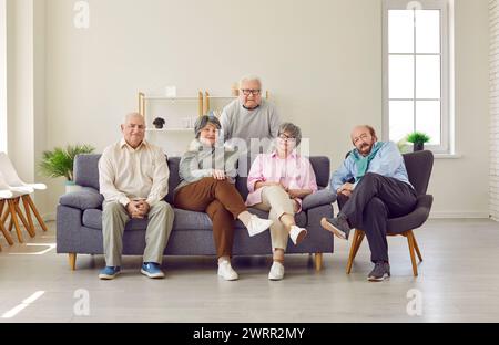 Gruppo di anziani, amici maturi seduti sul divano a casa Foto Stock