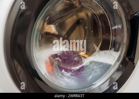 Primo piano della macchina lavatrice porta con la filatura servizio lavanderia Foto Stock