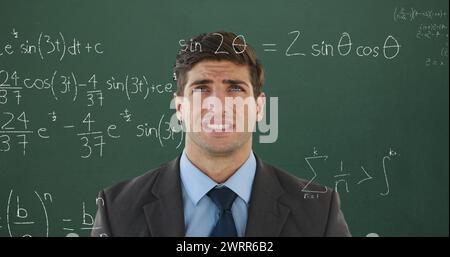 Confuso studente maschile con equazioni matematiche sullo schermo per il ritorno a scuola in 4K. Foto Stock