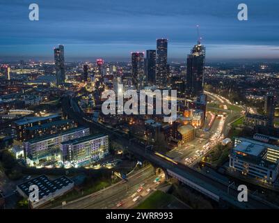 Immagine aerea al crepuscolo del centro di Manchester, Regno Unito durante l'ora di punta, tra cui Mancunian Way, Castlefield, Deansgate Square, Beetham Tower e oltre Foto Stock