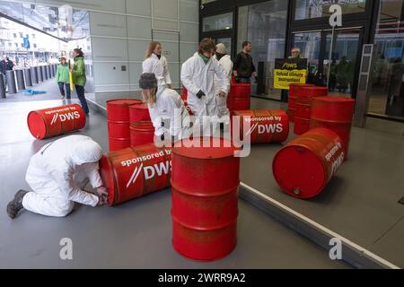 14 marzo 2024, Assia, Francoforte sul meno: Gli attivisti di Greenpeace protestano contro la politica di investimento di DWS Investment con tamburi rossi di petrolio davanti alla sede centrale dell'azienda a Francoforte. Foto: Boris Roessler/dpa Foto Stock