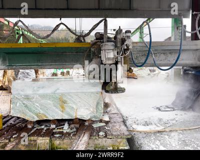 Macchina per il taglio del marmo che taglia un blocco di marmo in fabbrica Foto Stock