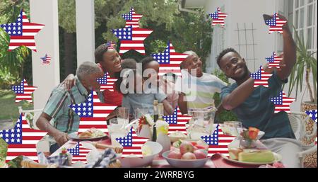 Immagine di stelle con bandiera degli stati uniti d'america che sventolano sulla sorridente famiglia afroamericana Foto Stock