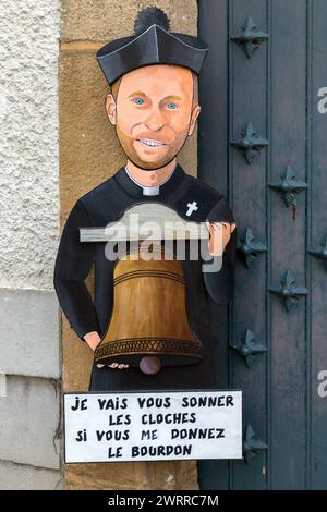 Caricatura umoristica del sacerdote di fronte al presbiterio nel villaggio. Navarrenx, Pirenei-Atlantici, Francia Foto Stock